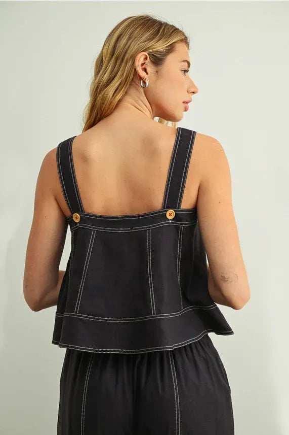 Black denim stitch detailed sleeveless top with white stitching and gold-tone buttons on shoulder straps