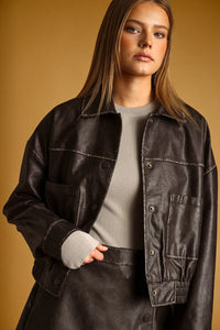 Black faux leather bomber jacket with silver toned buttons and contrast stitching featuring washed effect button front design