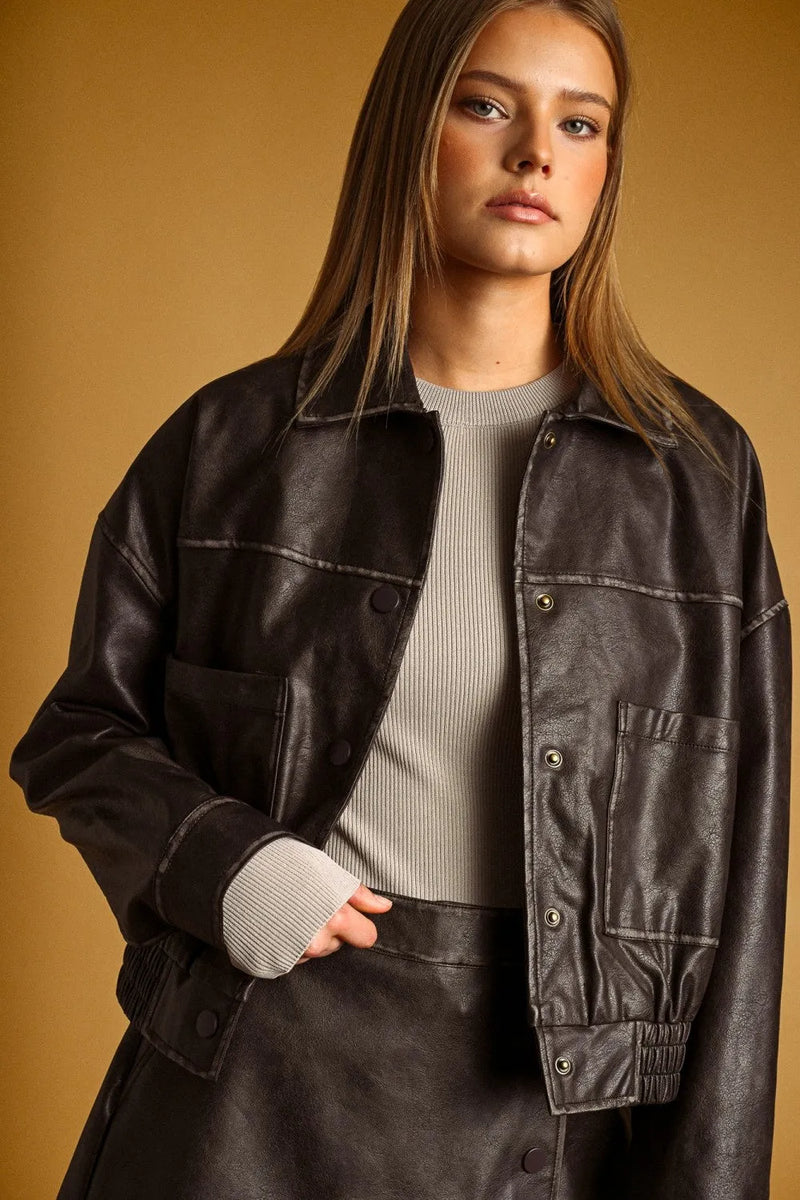 Black faux leather bomber jacket with silver toned buttons and contrast stitching featuring washed effect button front design