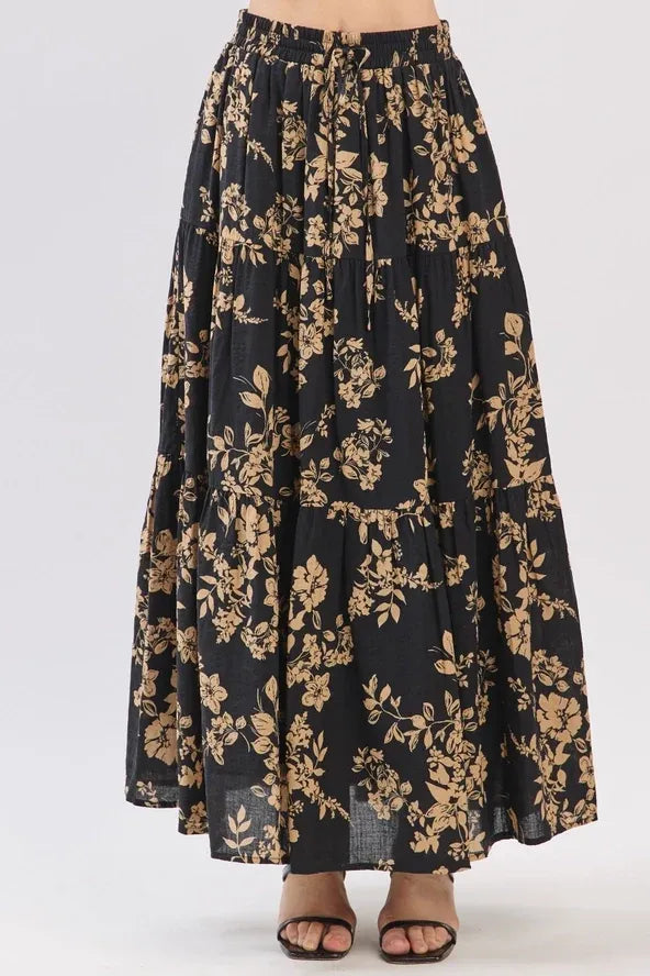 Black drawstring tiered midi skirt with gold botanical print and tiered hem in lightweight fabric