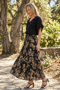 Black floral drawstring tiered midi skirt with gold toned leaf pattern and tiered design for elegant wear