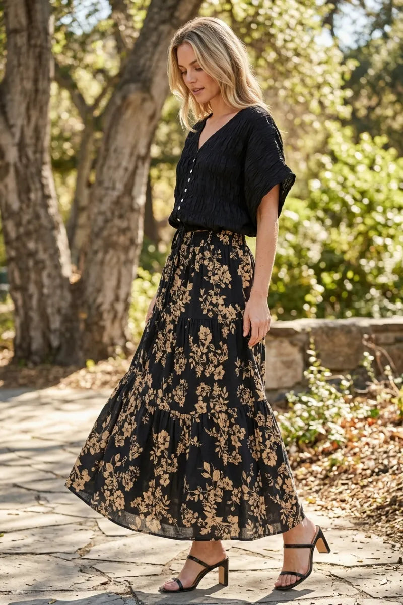 Black floral drawstring tiered midi skirt with gold toned leaf pattern and tiered design for elegant wear