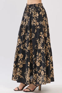 Black drawstring tiered midi skirt with gold botanical print and elastic waistband in lightweight fabric