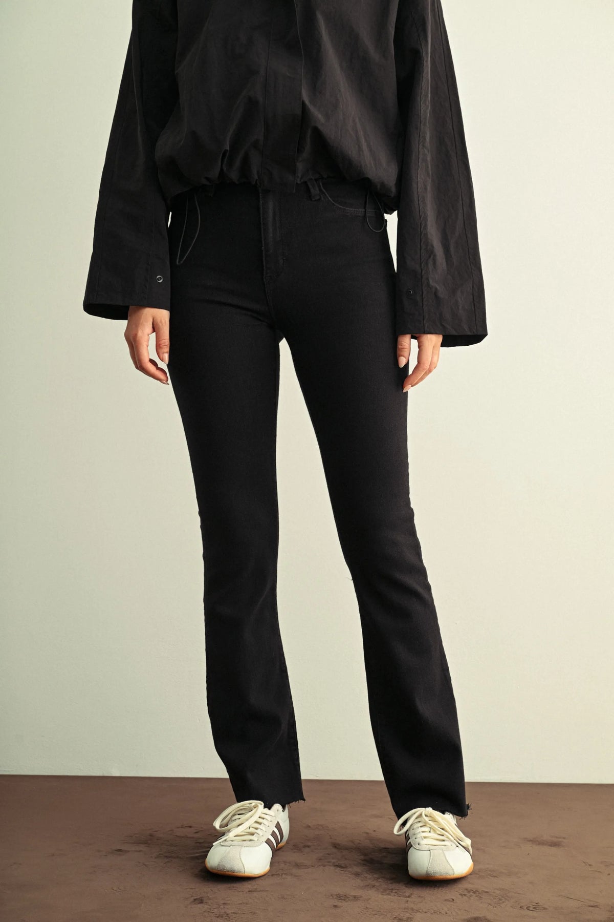 Black slim bootcut jeans with a slim fit, high-waisted flared legs, and subtle frayed hems for ladies