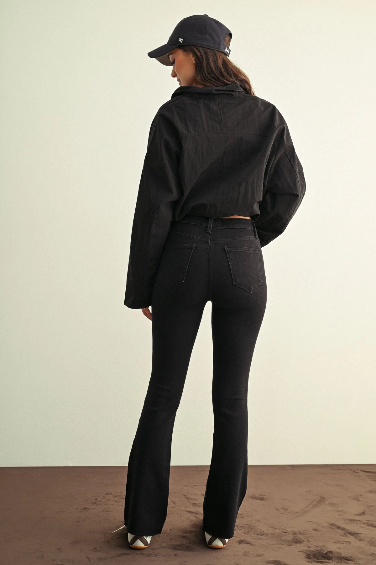 Black high-waisted slim bootcut jeans with a sleek slim fit silhouette and subtle stitching details for ladies