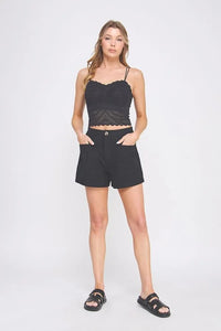 Black lace crop top with thin straps and scalloped hemline featuring a fine lace pattern scallop design