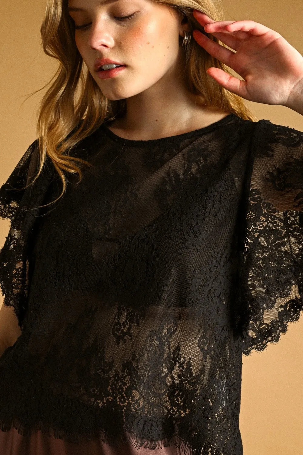 Black lace scalloped blouse with delicate floral patterns and sheer fluttery sleeves for elegant occasions