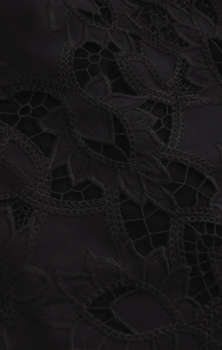 Black lace fabric with intricate floral patterns and delicate mesh detailing on midnight embroidered short sleeve top