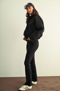 Black oversized cropped jacket with relaxed fit and long sleeves paired with ladies slim bootcut jeans