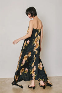 Black floral strapless pleated maxi column dress with gold and pink floral pattern and off-the-shoulder design