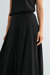 Black godet midi skirt with flowing lightweight fabric and side zipper detail for elegant wear