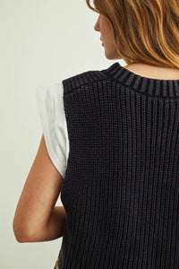 Black ribbed knit v-neck sweater vest worn over a white jersey top in sweater vest with jersey top combo set