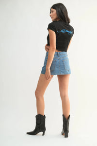Back view of black short sleeved crop top with blue embroidered ed hardy logo paired with classic mini denim high rise skort