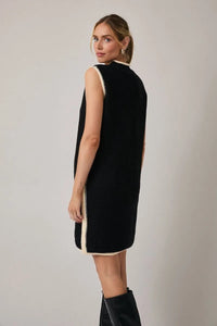 Black sleeveless knit sweater dress with cream trim features a mock neck and elegant sleeveless design