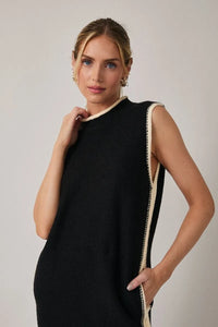 Black mock neck sleeveless sweater dress with cream trim along neckline and side seam in knit fabric