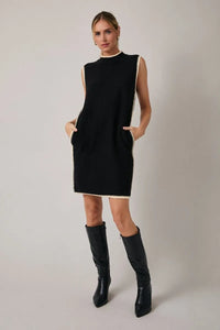 Black mock neck sleeveless sweater dress with cream trim along neckline side seams and hem in knit fabric