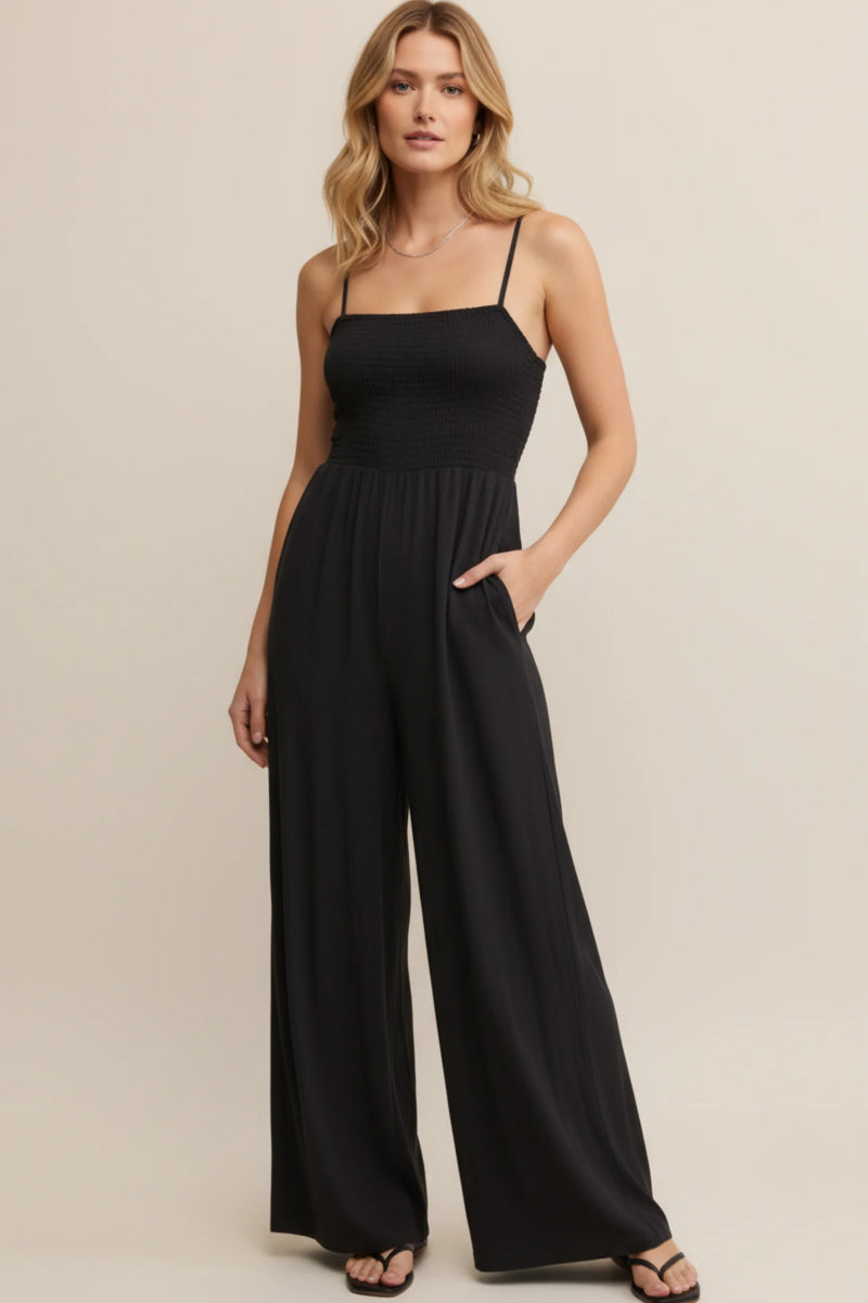 Black wide leg jumpsuit with adjustable straps and smocked bodice