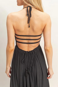 Black strappy halter neck maxi dress with smocked bodice tiered hem and back tie tassel detail shown from back