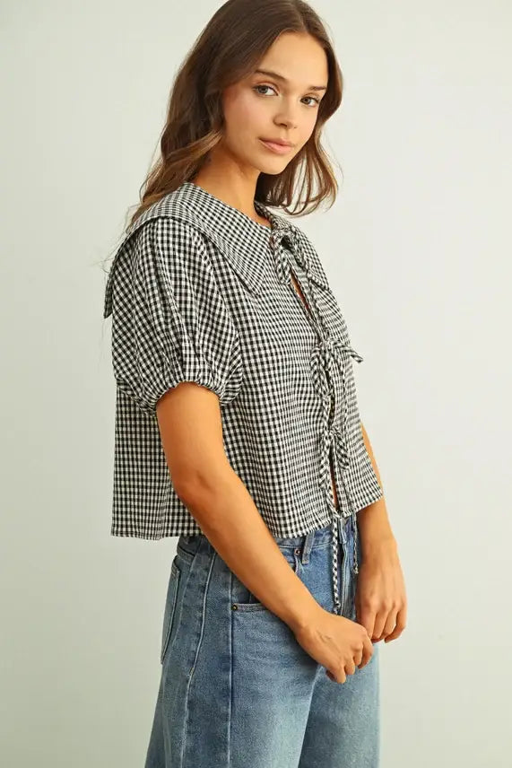 Black and white gingham short sleeve blouse with ruffled collar and front tie detail in a lightweight fabric