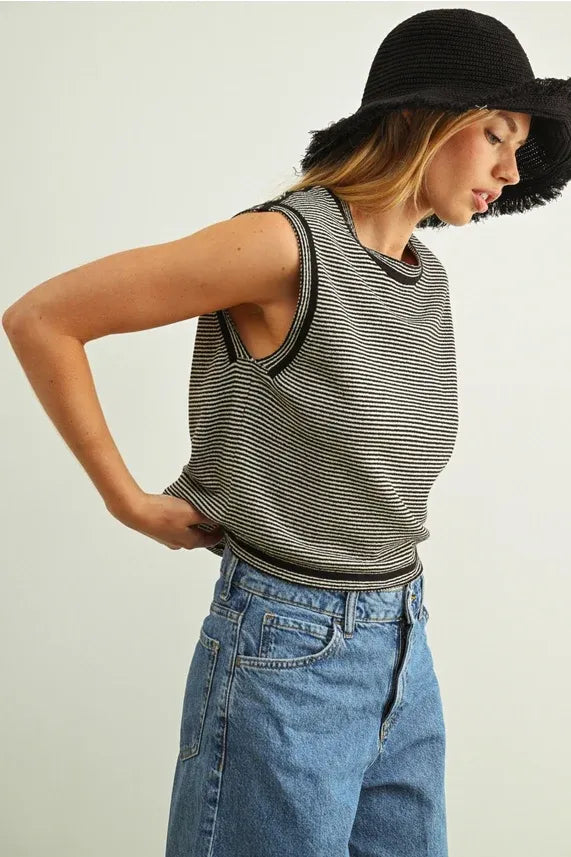 Black and white pinstriped sleeveless knit top with round neckline and cutout shoulder details