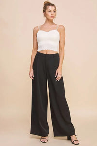 Black wide-leg trousers with sleek tailored fit and subtle creases complement a laser cut scallop edge bralette cami