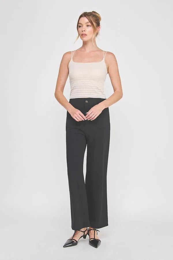 Black wide-leg trousers with sleek straight-cut silhouette and single front button closure complement zig zag patterned bralette cami