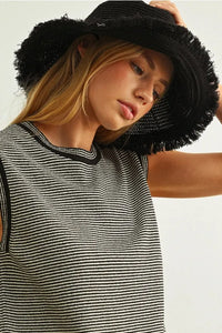 Black woven straw hat with frayed brim paired with pinstriped sleeveless knit top for stylish summer wear