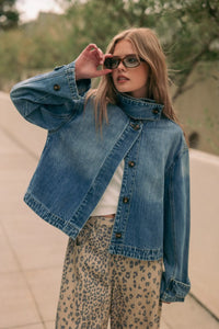 Blue denim jacket with high collar and button closures featured as a shirts styled denim jacket