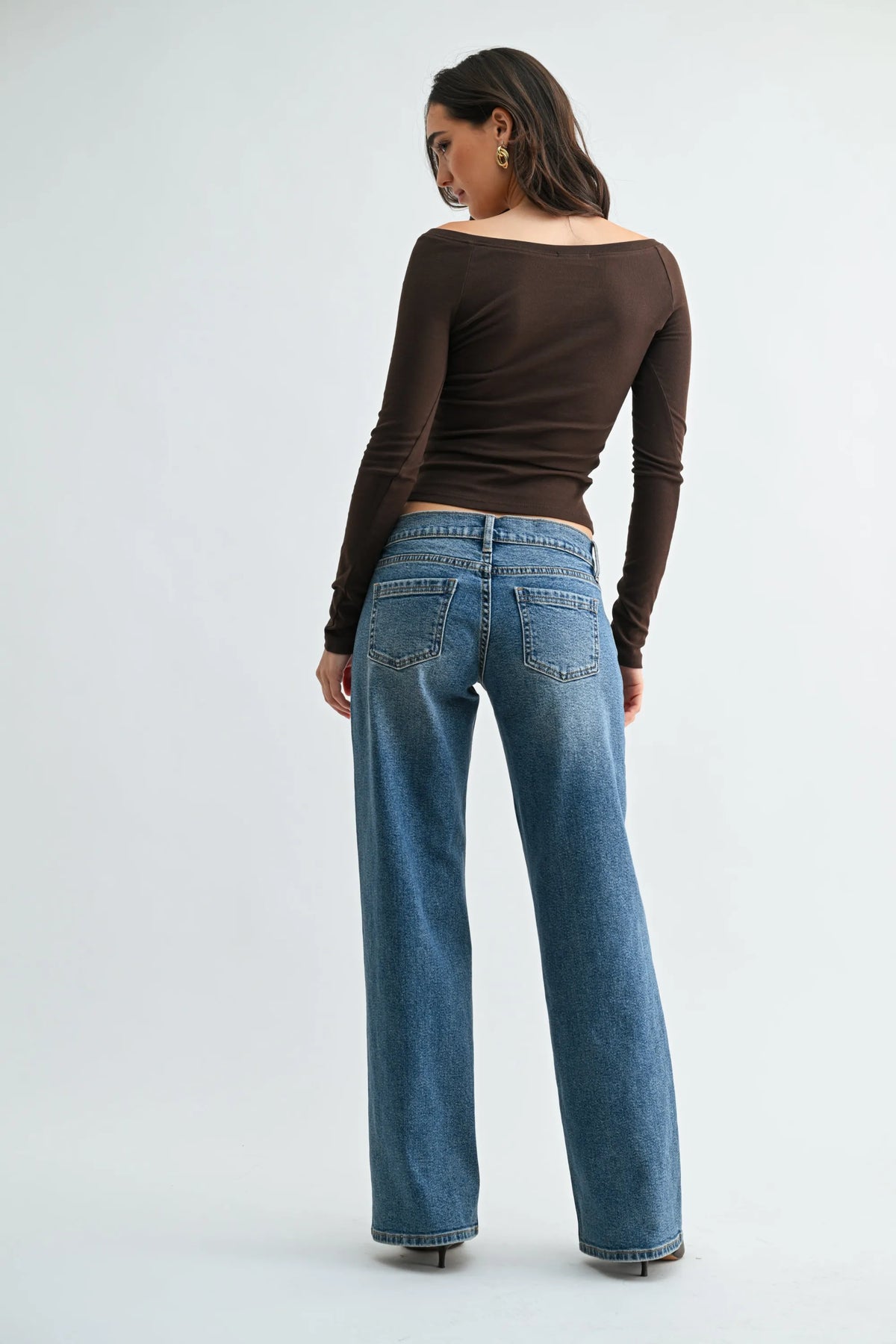 Blue denim low rise relaxed straight jeans showing the back side with classic pockets and straight-leg cut