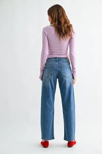 Blue denim mid rise bowed straight leg jeans showing the back side with classic straight leg pockets