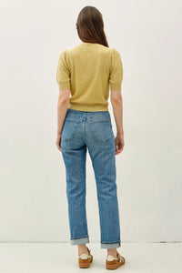 Blue denim jeans with rolled cuffs paired with a pointelle puff sleeve cardigan highlighting the puff sleeve detail
