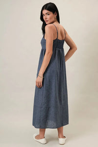 A flowing blue denim-like midi dress with sweet heart neck and thin heart neck spaghetti straps and gathered waist