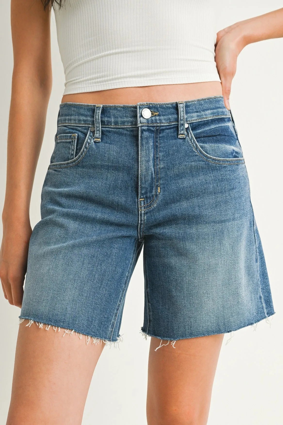 Blue denim mid rise bermuda jean shorts with frayed hem and classic five-pocket rise bermuda denim design