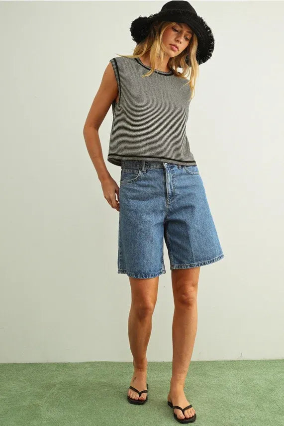 Blue denim shorts with straight-leg cut and frayed hem paired with pinstriped sleeveless knit top