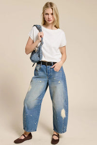 Blue distressed denim jeans with faded wash and tears paired with a lightweight knit short sleeve tee