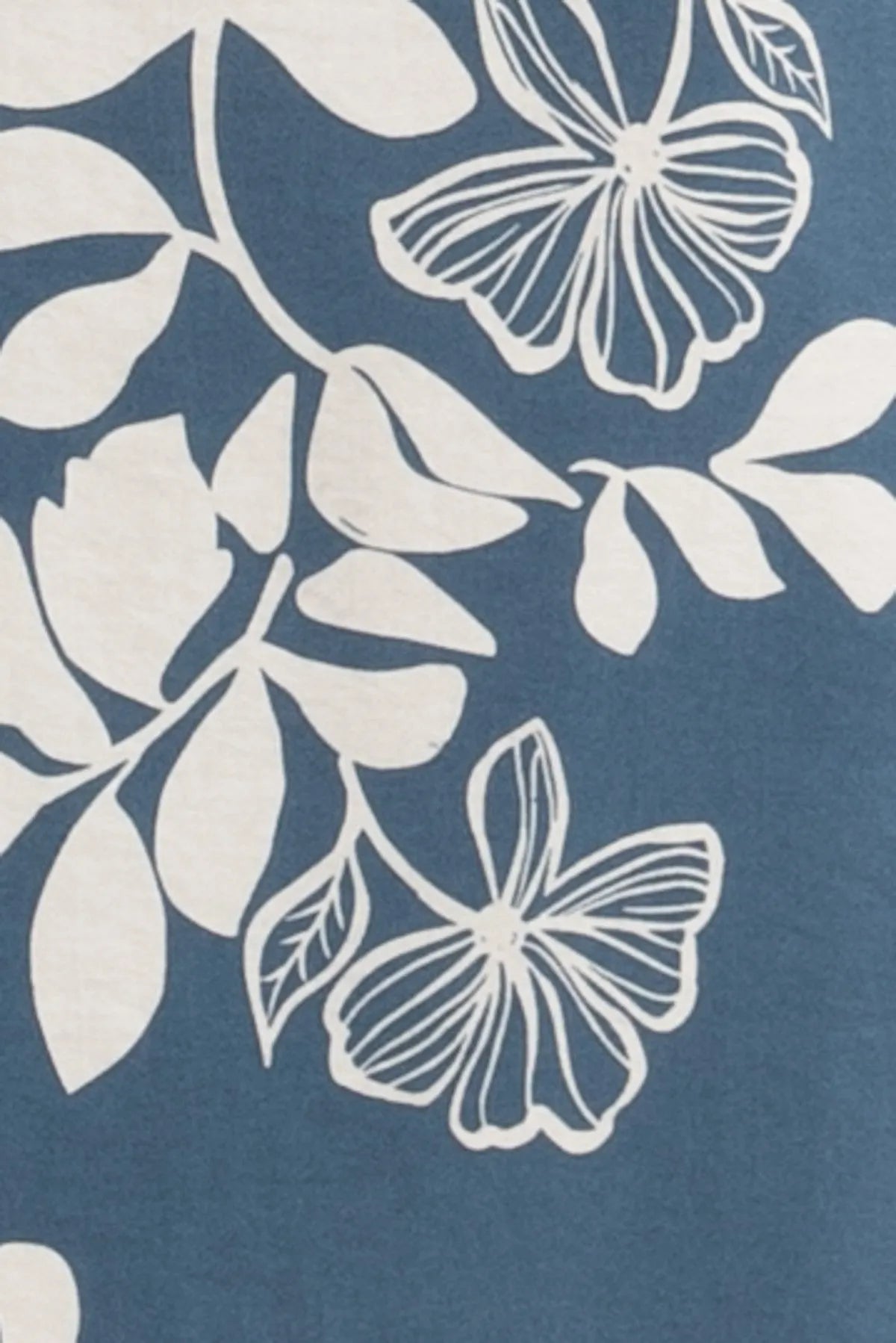 Blue fabric with white floral and leaf patterns on the back of a print back cut off cami midi dress