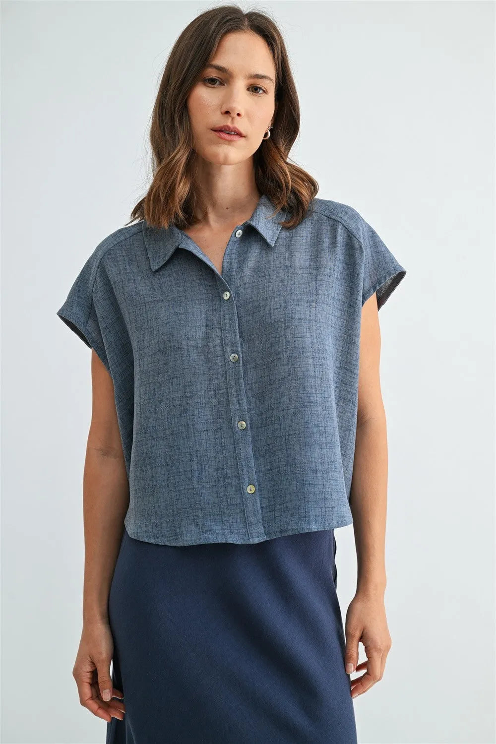 Blue linen dolman sleeve button down shirt with subtle textured weave and light green sleeve buttons