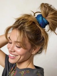 Blue patterned fabric scrunchie holding a messy blonde bun with full boho bandeau headband navy patchwork design