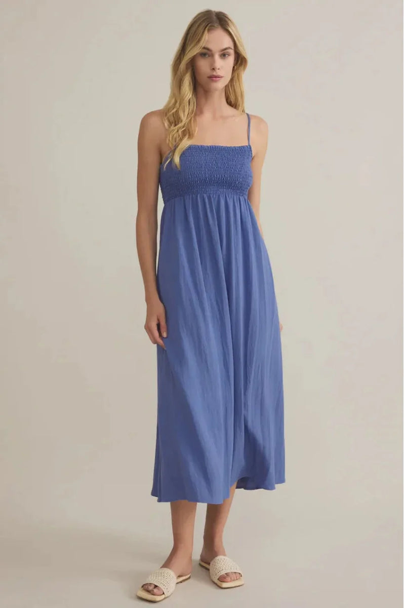 Beachside smocked midi dress with flowing blue fabric and spaghetti straps