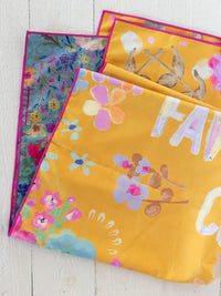 Double sided microfiber beach towel featuring bright yellow floral pattern pink trim and bold white favorite color lettering