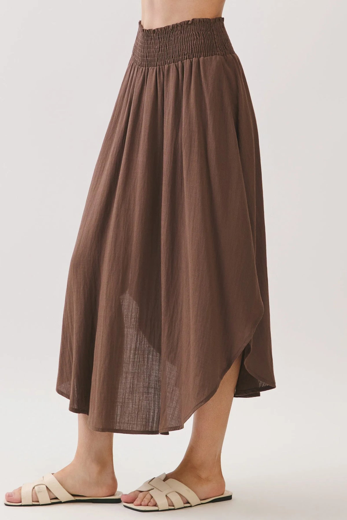 A flowing brown rounded hem midi skirt with a smocked waistband lined and sheer fabric panels