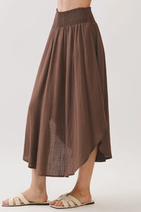 A flowing brown rounded hem midi skirt with a smocked waistband lined and sheer fabric panels