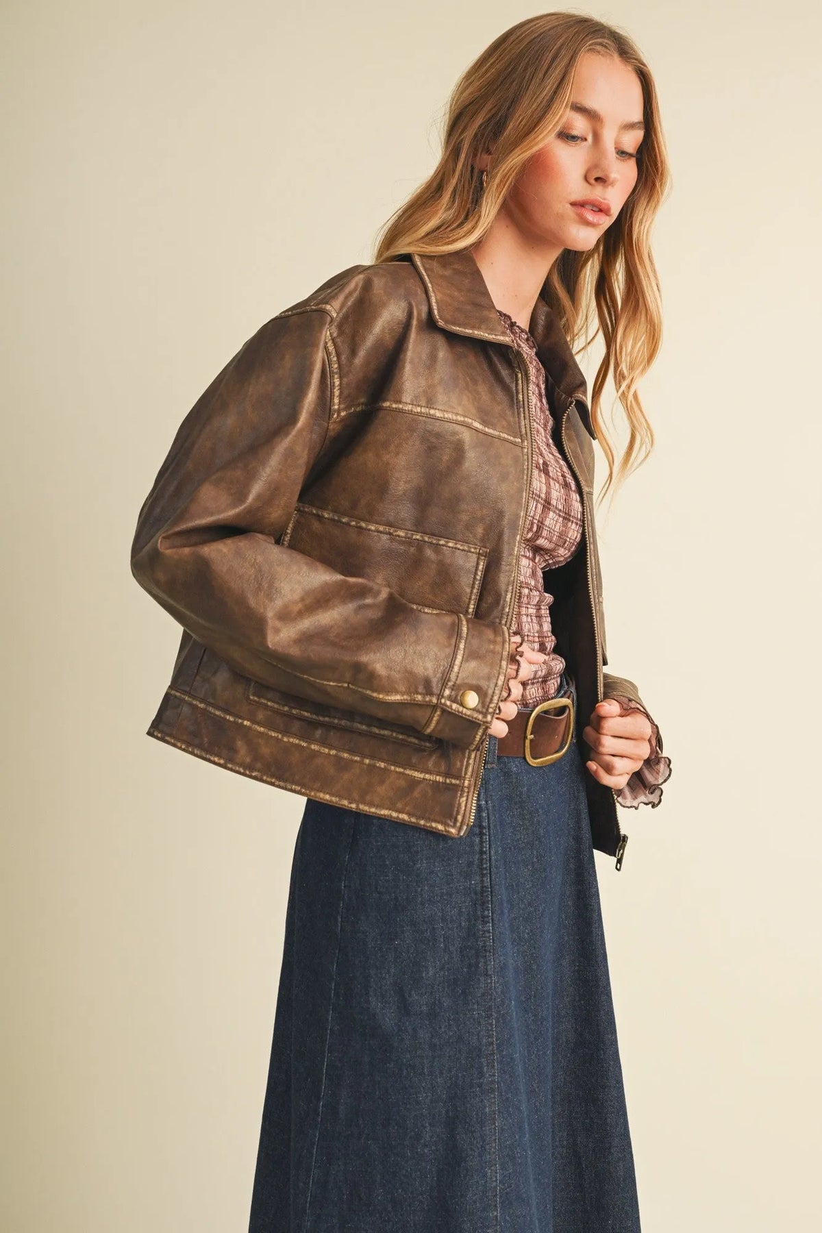 Brown distressed leather moto jacket with visible stitching and classic collar in coated knit boxy utility style