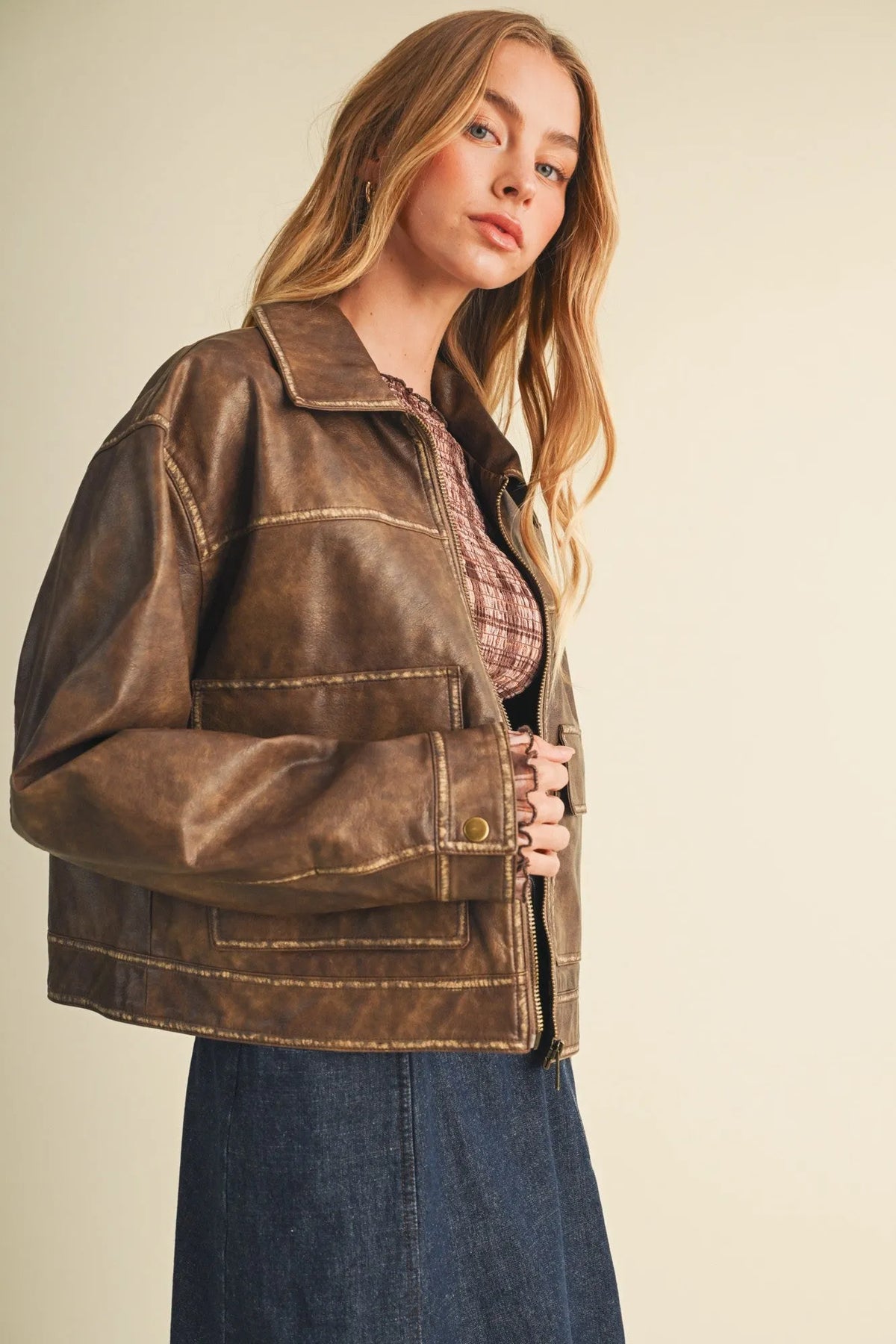 Brown faux leather coated knit boxy utility jacket with tan stitching and front zipper closure