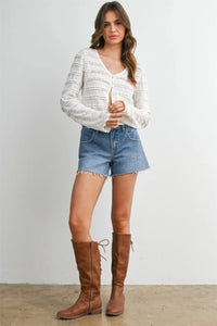 Brown leather lace-up knee-high boots styled with a ruched ribbon knit cardigan for a chic layered look