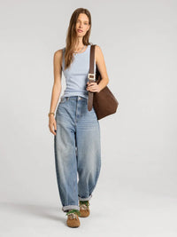 Brown leather shoulder bag with gold toned rectangular buckle paired with thread and supply edlin basic tank