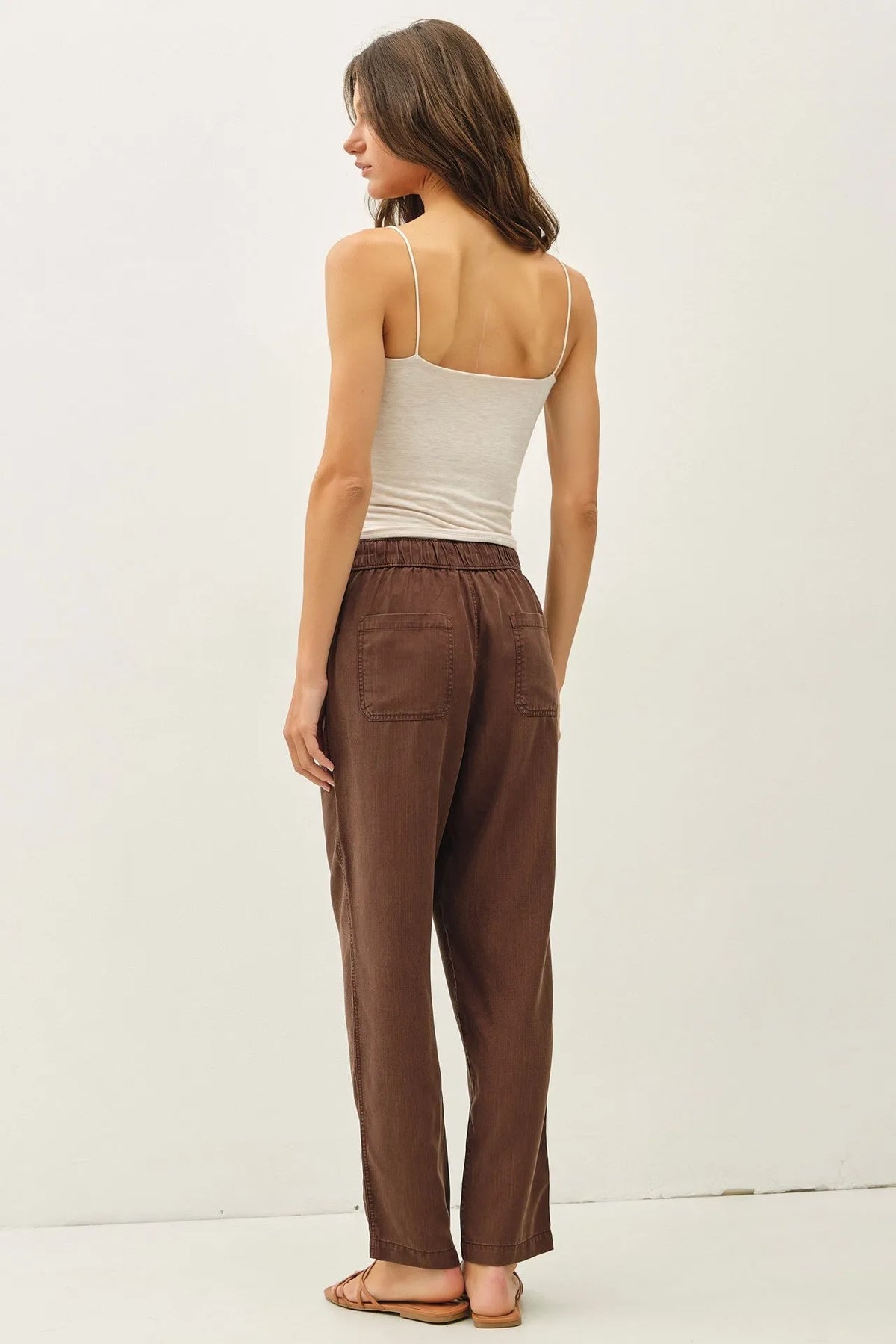 Brown relaxed-fit tencel tapered pants with elastic waistband and two front pockets for comfortable wear