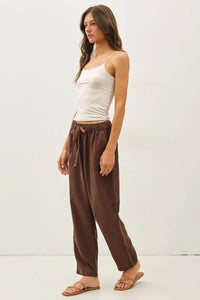 Brown tencel tapered pants with elastic waistband and drawstring tie in a relaxed fit design for comfort