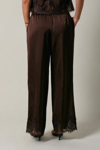 Brown satin wide-leg pants featuring elastic waist lace and black lace trim at waistband and hem