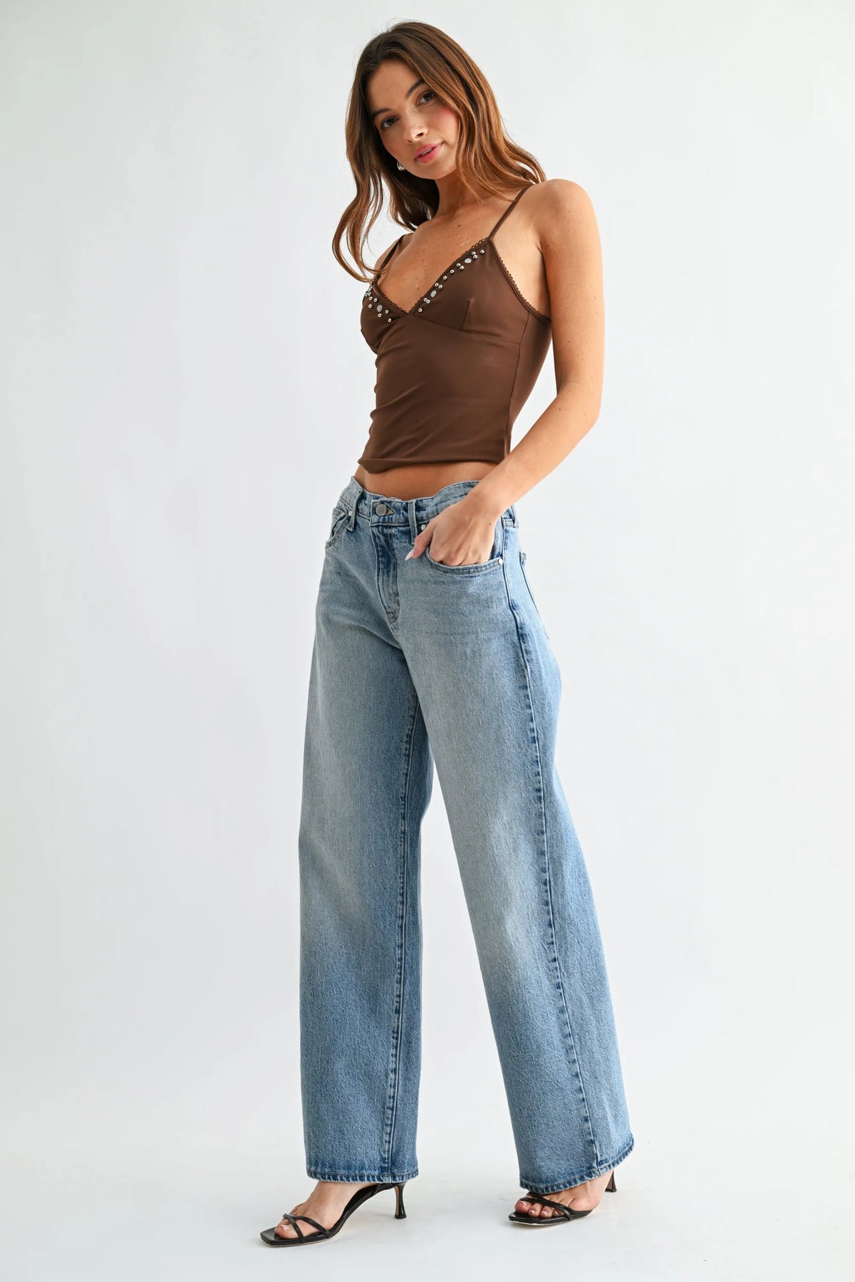 Brown studded spaghetti strap crop top paired with mid rise lightweight relaxed straight light-wash denim jeans